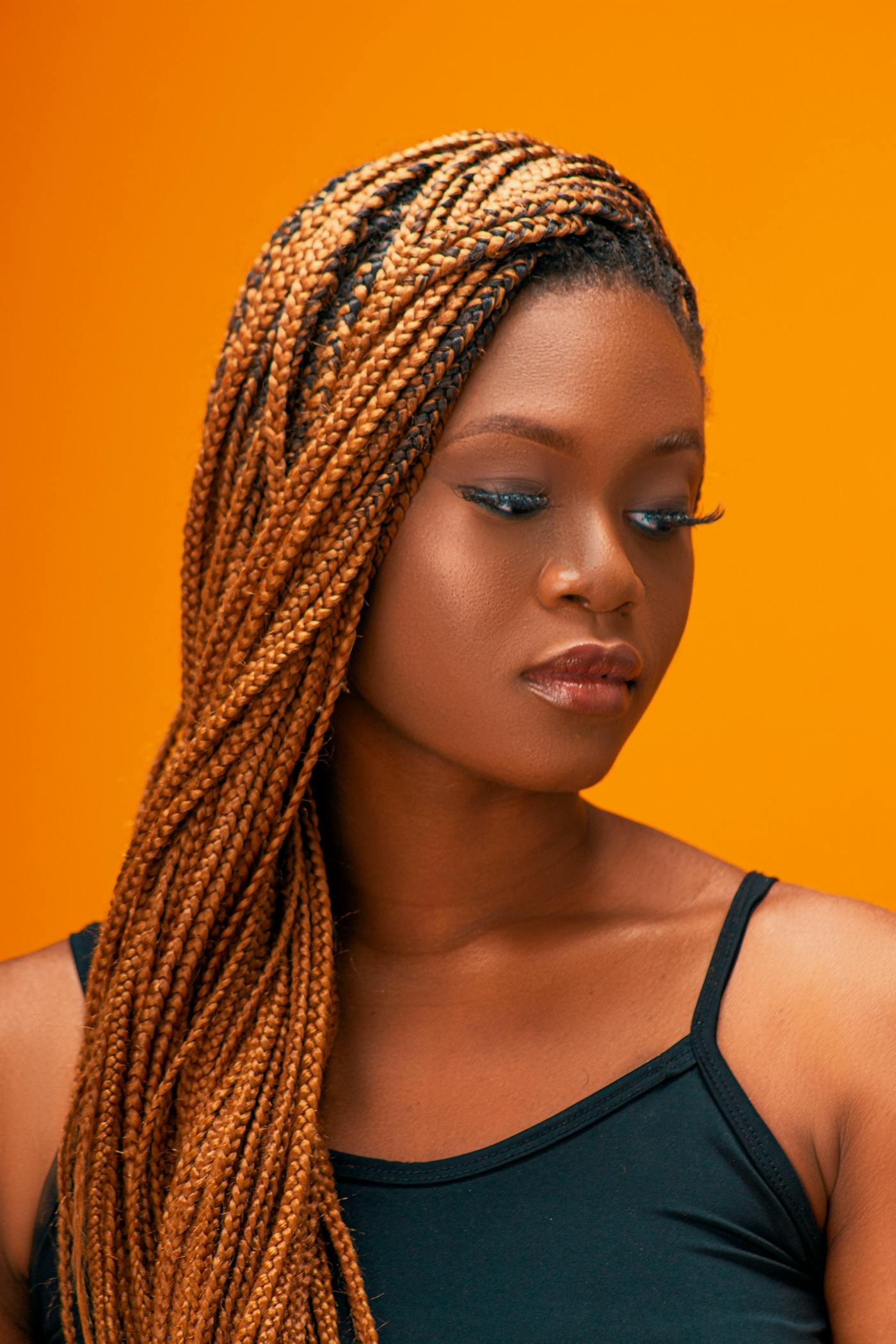 Copper-toned box braids on a warm background