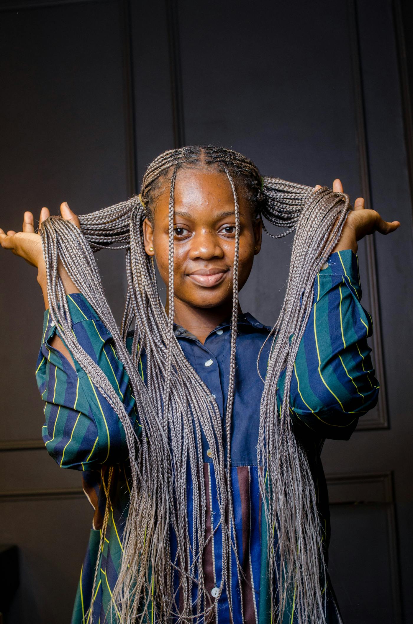 Very long knotless braids against a dark backdrop