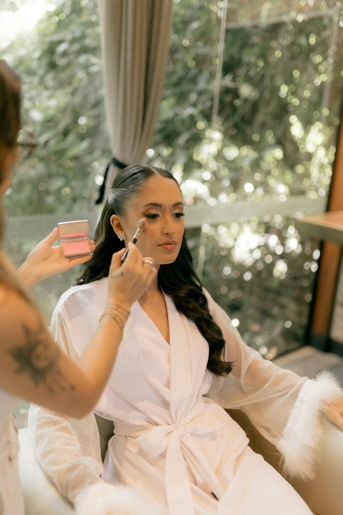 A bride having soft natural makeup applied before the day