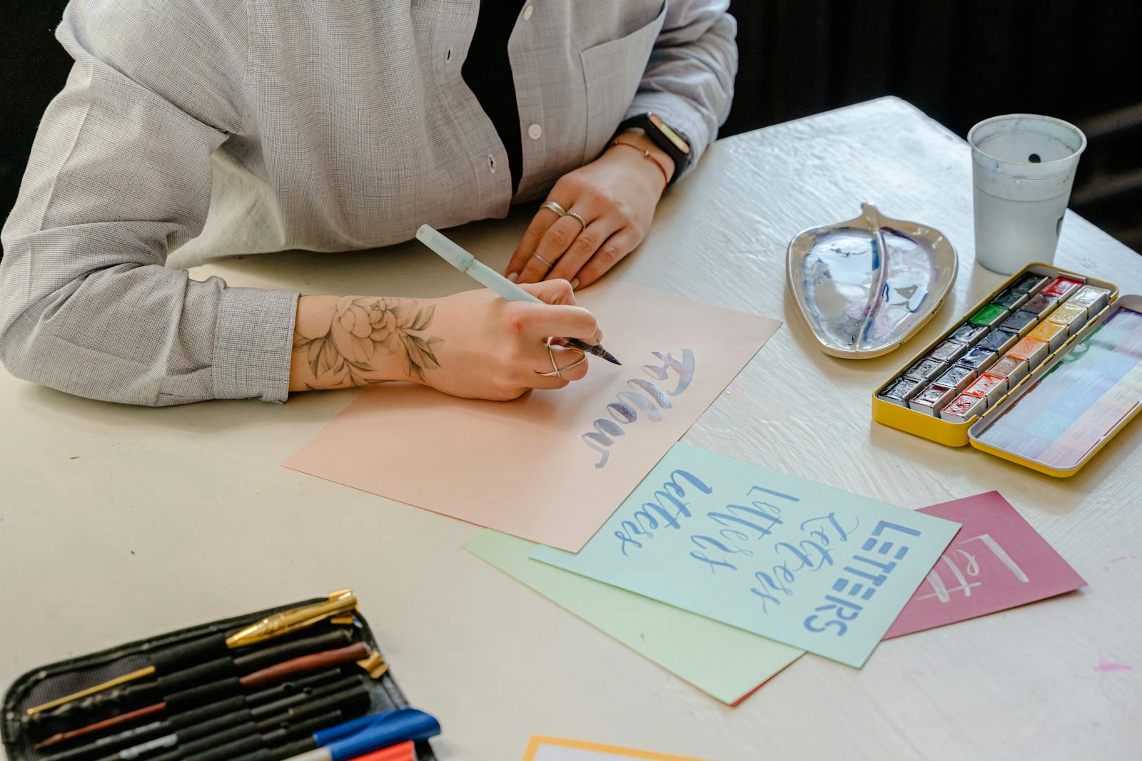 Artist hand-lettering custom script with a brush pen on paper