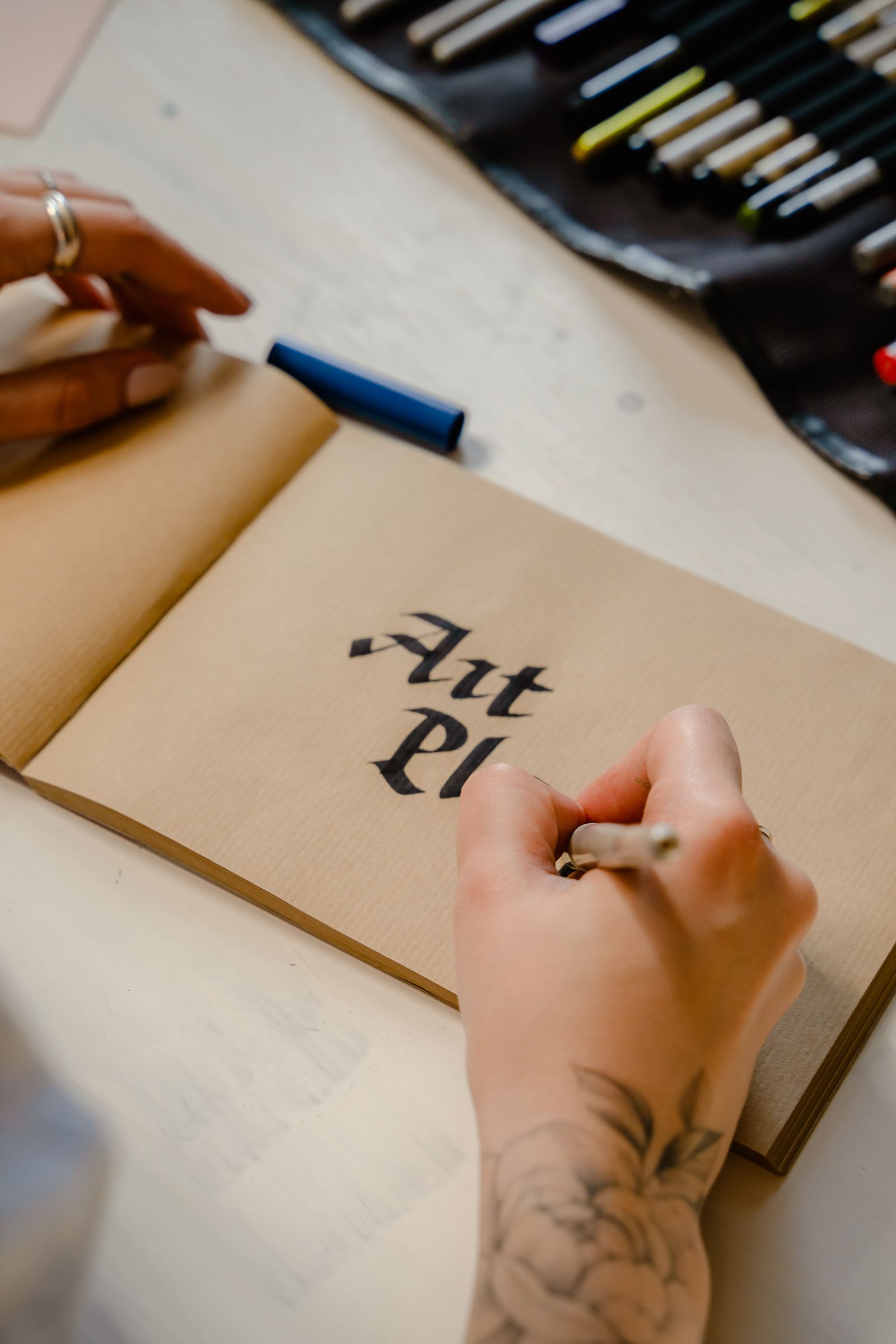 Blackletter hand-lettering practice on kraft paper