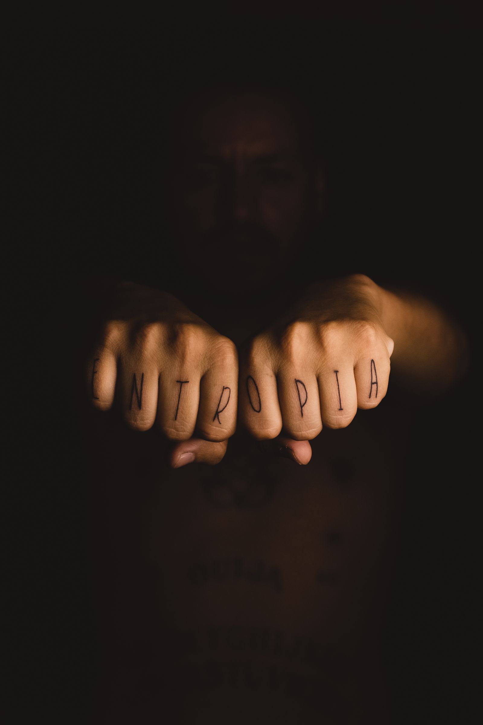 Knuckle lettering tattoo across two fists