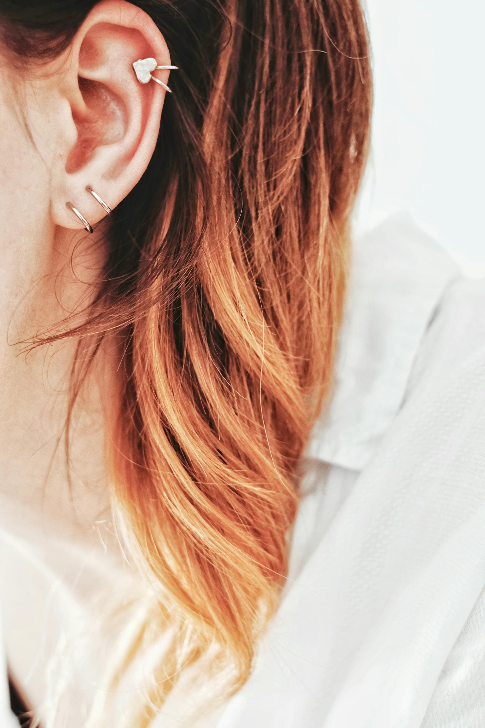 A heart ear-cuff with hoop piercings