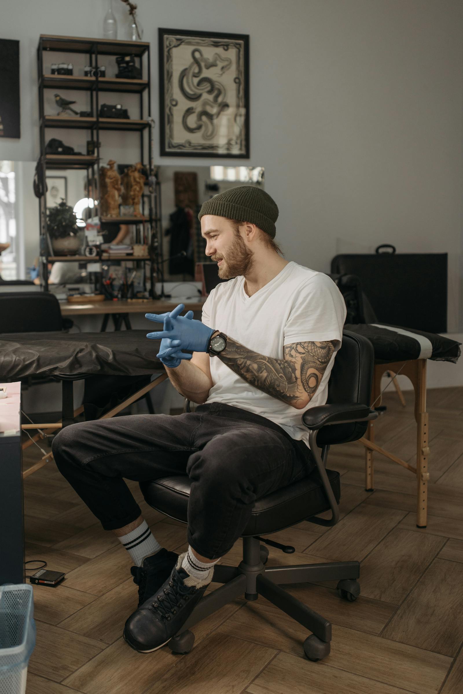 A relaxed artist gloving up in a bright, welcoming studio