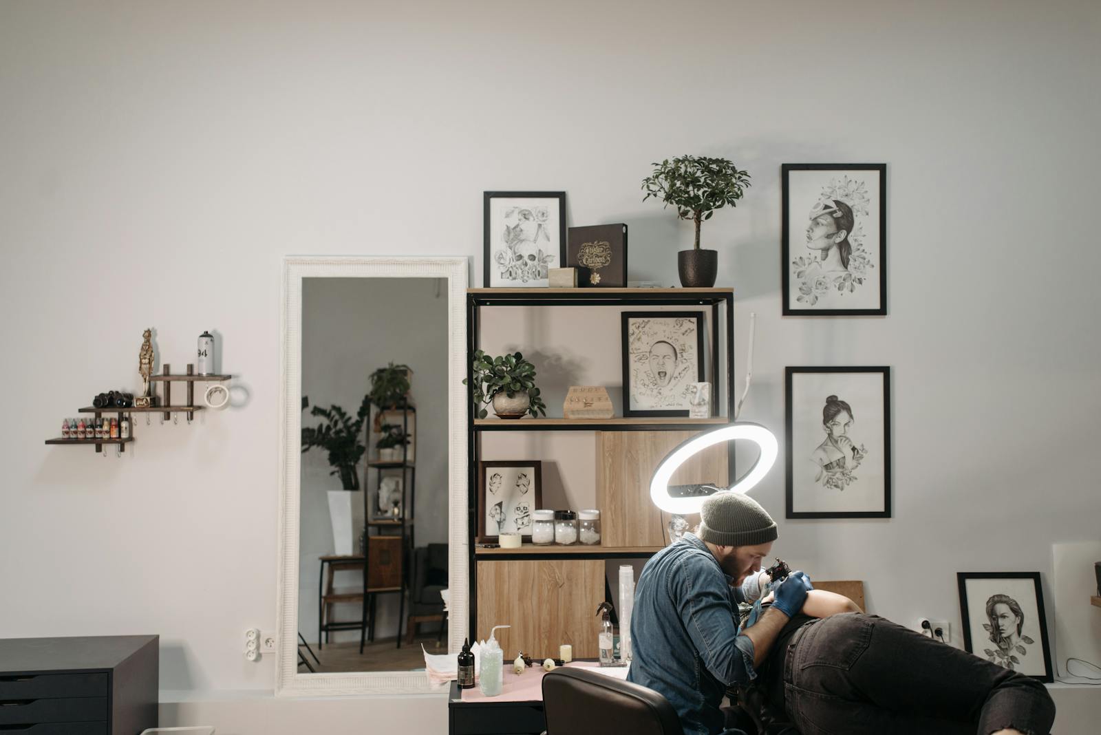 Inside the shop: framed artwork, plants and a tattoo station