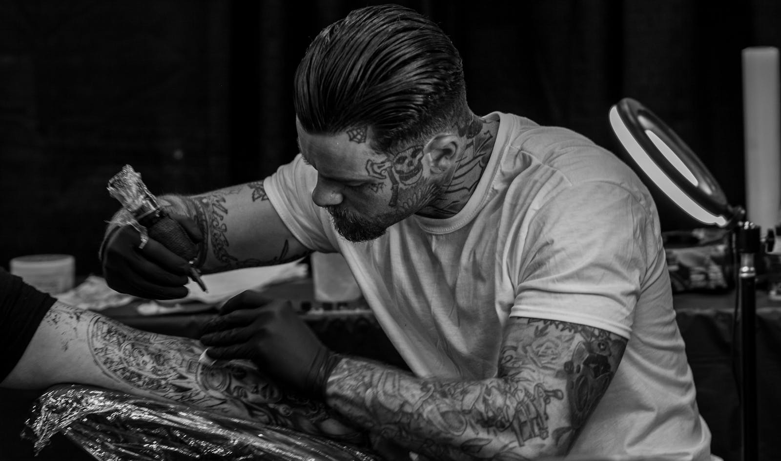 A tattoo artist focused mid-session, representative portrait