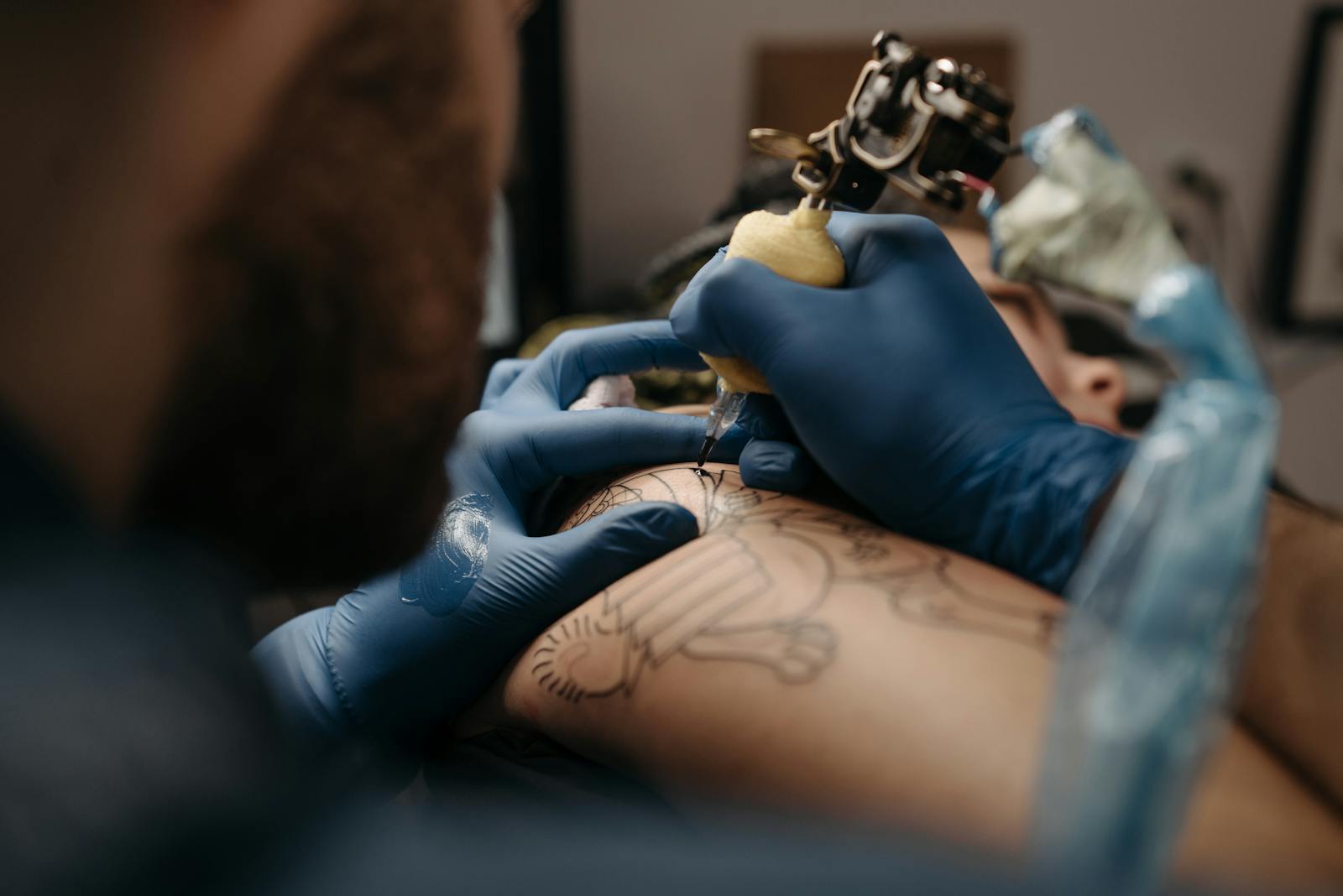 Close-up of a tattoo machine laying down line work